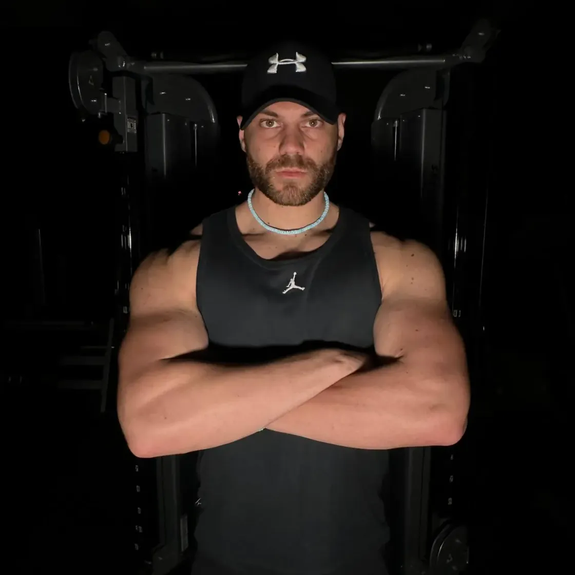 Luca Beltrami, chinesiologo e personal trainer, a braccia conserte in palestra